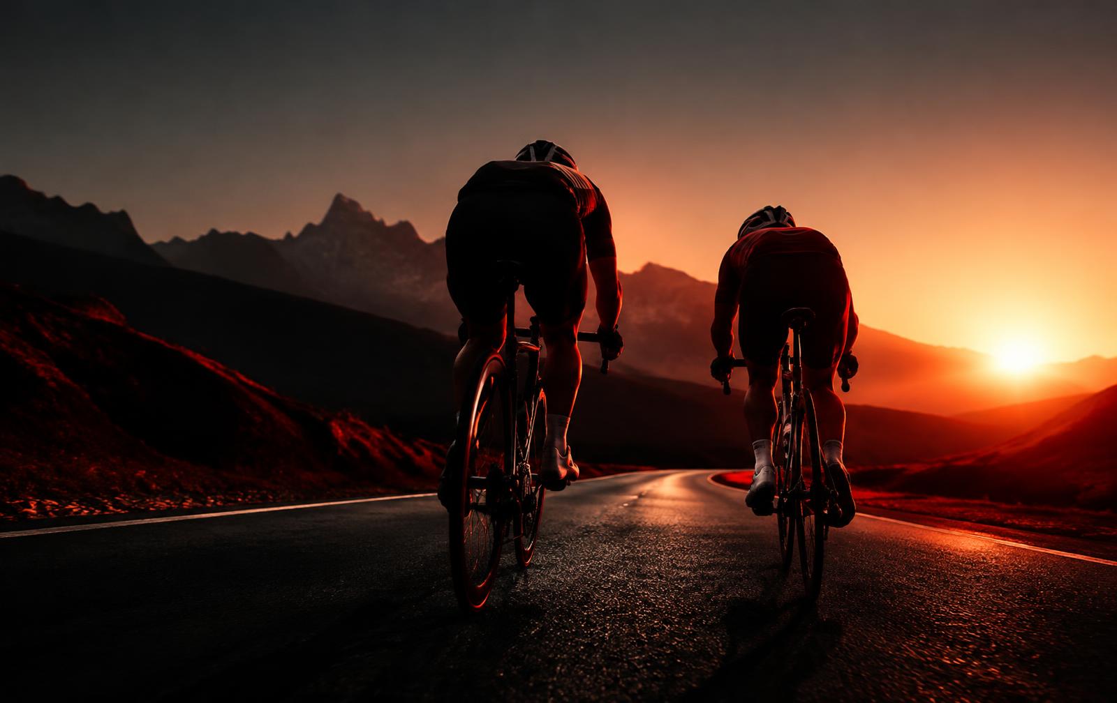 Two cyclists riding side by side at sunrise